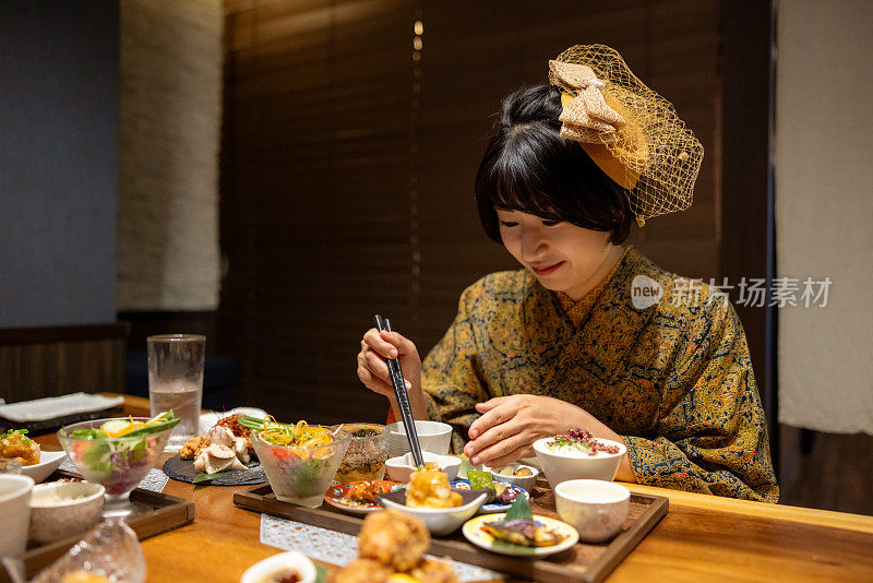 穿着和服/袴服的年轻女子在日本餐厅吃午餐